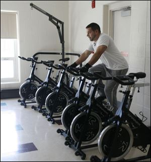 Below, Brian Blanton of Rossford works out on one of the recently acquired 12 spin bikes for fast-paced stationary cycling.