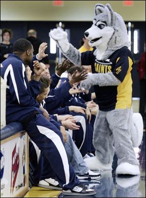 Halo the Husky gets acquainted with the men's junior varsity basketball team as Siena Heights' new school mascot.