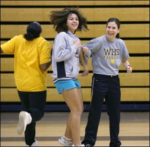 Tina Dake, right, participates in a running game with students Kristen Smith, left, and Alicia Bodette. About 140 Whitmer students are enrolled in Mrs. Dake's individual fitness course.