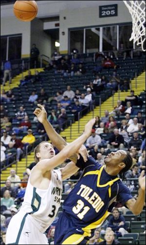 Wright State s Scott Grote fights for position with Toledo s Tyrone Kent for a rebound last night at the Nutter Center.