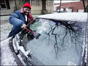 Charles Frazier scrapes ice off his windshield after leaving work at the Family House on Indiana Avenue yesterday. Highs are expected to be in the 30s today under partly sunny skies, but an Alberta Clipper dipping toward the area tomorrow will bring slightly cooler temperatures and some light snow. 