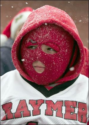 NBRE parade11p   12/06/2008     BLADE PHOTO/Lori King  Raymer football player Andrew Mierzejewski, 10, shields his face from the cold as he rides on his football team's float during annual Christmas parade in East Toledo, OH. His team is 16-0, which back to back undefeated seasons.