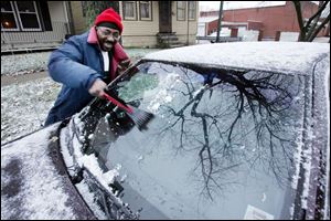 Charles Frazier scrapes ice off his windshield after leaving work at the Family House on Indiana Avenue yesterday. Highs are expected to be in the 30s today under partly sunny skies, but an Alberta Clipper dipping toward the area tomorrow will bring slightly cooler temperatures and some light snow. 
