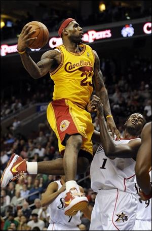 Cavaliers star LeBron James soars over 76ers center Samuel Dalembert on his way to the basket last night in Philadelphia.