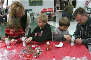 NBRE santa11p   12/06/2008     BLADE PHOTO/Lori King  from left: Kelsey Depinet, 6, her mom Linn Depinet with son, Adam Depinet, 7; and Garret Anderson with dad, Troy Anderson, make Christmas crafts during Oregon-Northwood Rotary Club's Breakfast with Santa at Clay High School in Oregon, OH.