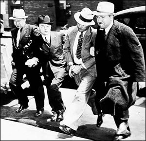Harry Campbell, handcuffed, is surrounded by J. Edgar Hoover s G-men after his capture on Monroe Street, just past 21st Street, in 1936. Campbell was No. 1 on the FBI s Most Wanted list. 