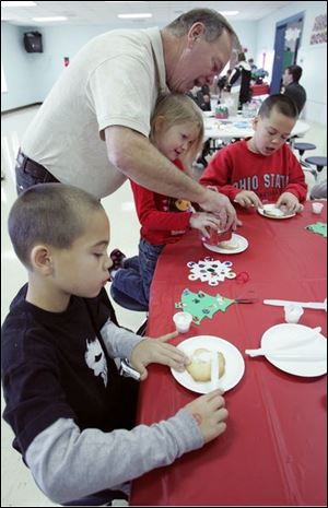 NBRS santa18p  12_13_2008      Blade Photo_Lori King  kids from left: Springfield Township residents Logan Spangler, 7, Camryn Miller, 4 and Trevor Spangler, 10, decorate cookies with their grandfather, Stanley Spangler, of Rossford, during Breakfast with Santa at Springfield HS in Holland, OH.