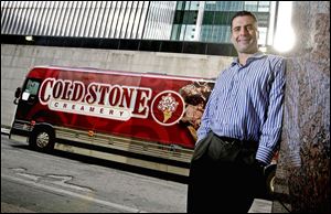 Dan Beem, Coldstone Creamery president, relaxes beside the tour bus he is using to visit franchisees.