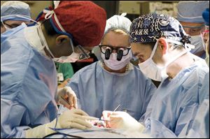 Dr. Risal Djohan, left, Dr. Maria Siemionow, and Dr. Daniel Alam perform a near-total face transplant at the Cleveland Clinic. Only three operations have been done worldwide.
