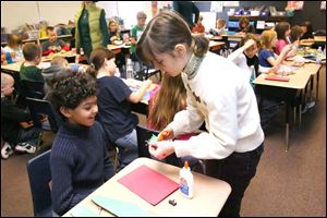 Rose Younglove, right, helps Hannah Sweat create a greeting card as part of a project at Christiancy Elementary.