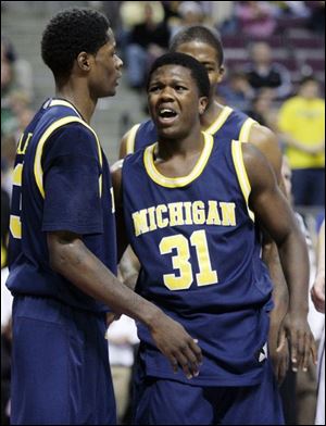 Michigan guard Laval Lucas-Perry (31) talks with teammate Manny Harris, left, after getting fouled late in the second half of their game against Oakland, Saturday in Auburn Hills, Mich.