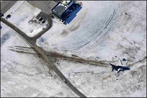 Continental Airlines Flight 1404 rests in a snow-covered shallow ravine Sunday after veering off the runway Saturday night.