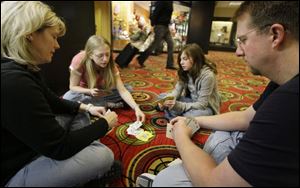 Tom and Kristina Waltz of Vancouver, Wash. play cards with their daughters, Jessica, left, and Samantha on the lower level of the O'Hare Hilton Wednesday, in Chicago. The Waltz' are spending their second night at O'Hare because of bad weather.
