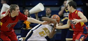 Toledo s Clayton Sterling (21) steals the ball from Illinois-Chicago s Jeremy Buttell, left, and Robo Kreps last night.