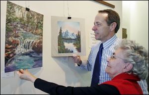 Fred Moor and Martha Baldoni examine the artwork on display this month in the Perrysburg Municipal Court Building.
