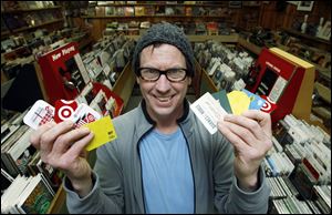 Culture Clash owner Pat O'Connor shows off gift cards from competitors that he accepts.