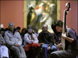 Slug:  CTY chinese05p Date:  01042009        The Blade/Andy Morrison       Location:  Toledo       Caption: Yitong Jiang from the University of Toledo, performs a PiPa solo during the Chinese Association of Greater Toledo's 2009 Winter Legacies Program at the Toledo Museum of Art, Sunday, 01042009.    Summary: