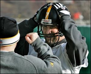 Steelers quarterback Ben Roethlisberger has his helmet adjusted before practice Monday in Pittsburgh.