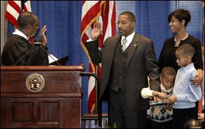 U.S. District Judge Algenon Marbley, left, swears in Kevin Boyce as wife Crystal, and sons Kristopher and Kevin, Jr., watch. 