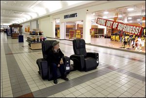 Tom Lucet of Beverly, Mass., takes a solitary break in the Liberty Tree Mall in Danvers, Mass., where clothing retailer Steve & Barry's, a victim of the sour economy, holds a going-out-of-business sale. 