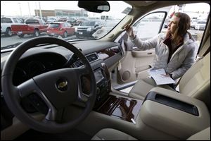 Katie Cummings peruses the features of a Chevrolet Tahoe at a dealership in Grinnell, Iowa. Experts say it is a car buyer's market and some dealers are seeing more customers.