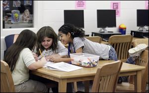 Nancy Potts, 10, left, and sister Shelby Potts, 11, get some help from Myah Reed, 11, during the PowerHour after-school homework program through the Boys and Girls Club of Toledo at Sherman Elementary. 