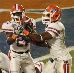 Florida s Major Wright, left, gets a little help from Ryan Stamper while intercepting a pass from Oklahoma s Sam Bradford. 