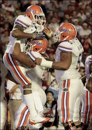 Florida s Percy Harvin, left, celebrates with his teammates after his third-quarter touchdown gave the Gators the lead.