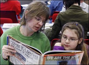 Annette Carroll of Whitehouse and daughter Faith, 9, pitch in at the library. Faith was among the few children to participate.