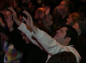 Marty Self of Holland lifts his hands in prayer during the opening of the Holy Toledo Day of Prayer at the Valentine Theatre.
