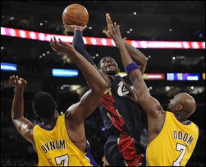 Cavaliers forward LeBron James shoots over Lakers center Andrew Bynum, left, and forward Lamar Odom in first half Monday night.