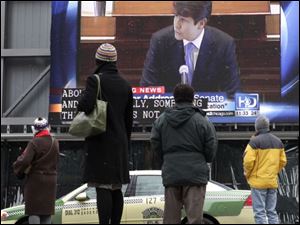 Pedestrians in downtown Chicago stop to watch a live broadcast of Rod Blagojevich delivering his closing argument at his impeachment trial in Springfield, Ill.