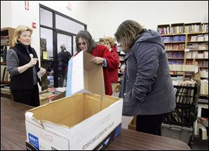 Margi Levy, left, coordinator of the Friends of Toledo-Lucas County Public Library, explains the group s first book sale of the year to Lisa Marlatt and Paula Rodlund, right, with the Lenawee Intermediate School District. The two arrived at the sale yesterday at the Friends  Book Center with boxes they hoped to fill with bargains for the district.