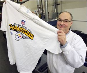 Les Arquette of Image Group holds a prototype of a children's T-shirt the firm will print if the Steelers win. 