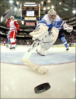 Penguins goalie Marc-Andre Fleury reaches for the puck but can t prevent a goal by the Red Wings  Pavel Datsyuk, left.