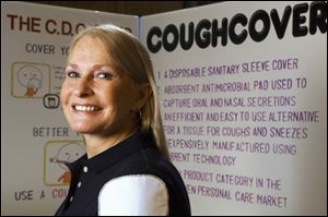 Retired nurse anesthetist Michele Strocel models the CoughCover on her shoulder. CoughCover is a pad that sniffly people can affix to their shirts and cough or sneeze into.