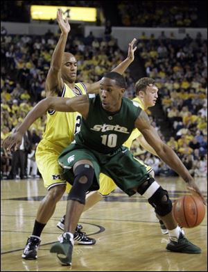Michigan State forward Delvin Roe (10) is defended by Michigan guard C.J. Lee during the first half last night at UM's Crisler Arena. Roe scored 11 of his season-high 14 points in the half, while teammate Kalin Lucas had 13 of his 15 points after halftime.