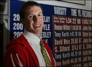 St. Francis senior Roman Willets stands by the school record board which includes his name for the 200-yard freestyle (1:40.06). Willets owns the best time in Ohio in three events this season.