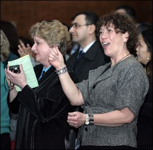 Michelle Susan Marentette Hermanutz, in the foreground, who came to this country from Canada, celebrates after taking the oath of citizenship.