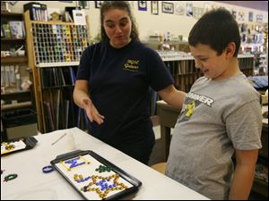 Slug:  CTY artclass23p                              Date 2/22/2009           The Blade/ Amy E. Voigt                     Location: Toledo, Ohio  CAPTION:  Amanda Fleming (cq one m), left, compliments her son Aaron Fleming, right, from Haskins, during Mom & Me: Nugget Madness at Prism GlassWorks, Ltd., which is designed for parents (or grandparents) to work alongside their children, using glass nuggets and  dots, to design and create ornaments, crosses, suncatchers, pendants and more.