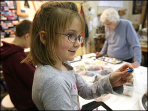 Slug:  CTY artclass23p                              Date 2/22/2009           The Blade/ Amy E. Voigt                     Location: Toledo, Ohio  CAPTION:  Brielle (cq) Heft,  from Haskins, shows her friend a particularly colorful piece of glass during Mom & Me: Nugget Madness at Prism GlassWorks, Ltd., which is designed for parents (or grandparents) to work alongside their children, using glass nuggets and  dots, to design and create ornaments, crosses, suncatchers, pendants and more.