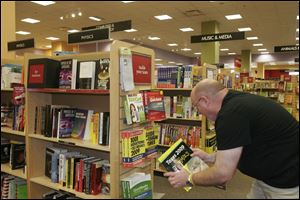 Borders general manager Pat Borden arranges tax-help books offered for the season at the store
on Monroe Street. Dozens of titles are available to aid taxpayers with changes in the tax code.