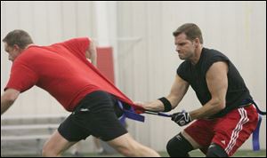 Dan Nowak, right, tries to pull the flag off an opponent during the football game at the center.