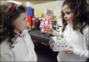 Lucy Arrigo, 7, left, listens as Jala Ehrenfried, 7, explains how she made her robot. All first graders at Glendale-Feilbach Elementary and their parents were challenged to build a robot.