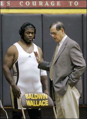 Mr. Haynes listens to coach Rich Fleming before a match against Heidelberg University. He finished the season 2-13 at Baldwin-Wallace College and hopes to return to wrestling next season.