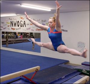 Napoleon junior Kendall Homan practices on the balance beam. Homan is a two-time defending all-around champion at the district and finished 15th at state last year. 