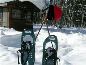 Snowshoes and trekking poles help hikers traverse  the woods in the Porkies.