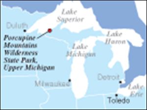 The Porcupine Mountains Wilderness State Park is Michigan s largest park.
 It was established in 1945 to protect the last uncut stands of northern hardwoods and eastern hemlock forest remaining in the Midwest.
The mountains here, reaching some 1,400 feet above mighty Lake Superior, stretch almost 2,000 feet above sea level, reaching 1,958 feet at Summit Peak, the high point in Michigan.
The Porkies  modern name derives from the Lake Superior Objiwa, who called them  Kaug Wudjoo,  or place of the crouching porcupine.
The park is just 20 acres shy of 90,000 and stretches 25 miles along the Superior shoreline.
It averages 10 miles deep, its southerly reaches abutting the Ottawa National Forest.
Nearly 48,000 acres of the park were designated as wilderness in 1994; motorized traffic is restricted to a few peripheral roads.
To reach its wild interior wonders, you go on foot except in winter, when snowshoes or cross-country skis are a must, particularly off well-used and well-packed Nordic trails.
 Snow can be five or six feet deep, more in drifts and ravines.
The Porkies lie in the western Upper Peninsula, some 300 miles west of the Michigan peninsulas  famed connector    the Mackinac Bridge.
 The mountains lie slightly north and 100 miles east of Duluth  and 200 miles northeast of Minneapolis-St.Paul.
 They are farther west than Madison, Wis., and lie on about the same longitude as the great easterly bend of the Mississippi River between Dubuque and Davenport, Iowa.
 They are 650 miles from Toledo, closer to Chicago than to Detroit, and part of Michigan s  spoils  after losing a southern border strip to Ohio in the infamous  Toledo War  in 1836.
  Steve Pollick