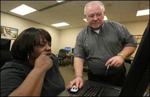 John Lula, right,  instructor of a basic computer class at The Source, works with Theressa Morgan.
