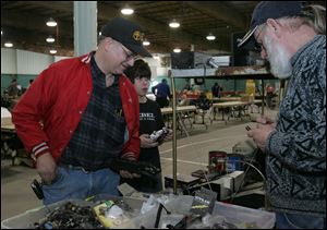 Jeff Scheid, left, and his son, Clement, look through the boxes of electronics parts for sale by Kenny Wood of South Bend, Ind.